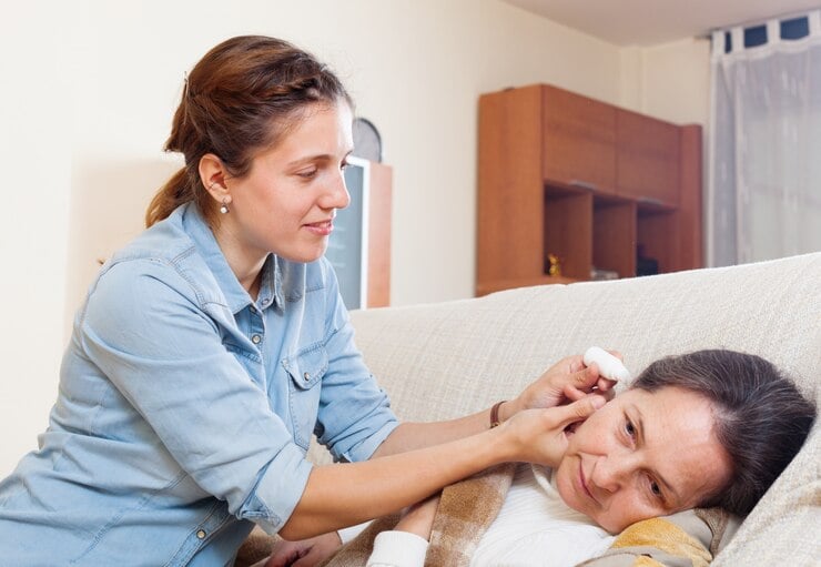 woman adding drops in ear